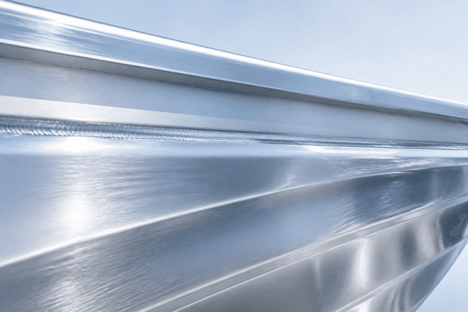 Bright brushed aluminum hull with weld seam in daylight